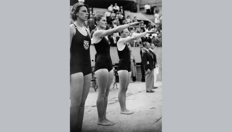 German swimmers wearing the insignia of the Nazi Germany, Miss Mathis and Robinson, perform the Nazi salute during the swimming competition of the International University Games, on August 1937 in Paris.- AFP file photo