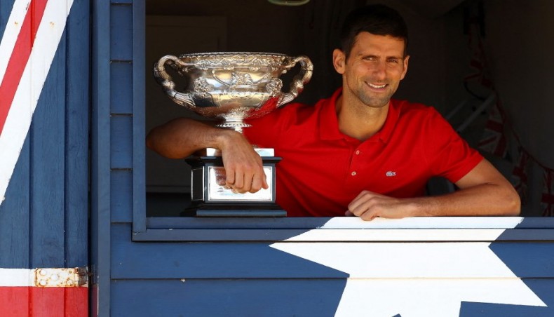Serbia's Novak Djokovic poses with the Norman Brookes Challenge Cup trophy during a photo shoot at the Brighton Beach in Melbourne on Tuesday. — AFP photo