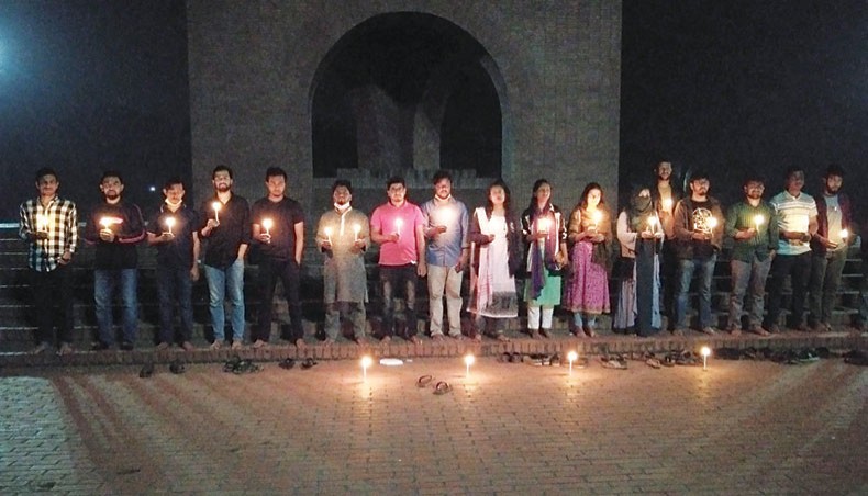 Jahangirnagar University students hold a candlelight vigil at the university Shaheed Minar at Savar in Dhaka on Tuesday in protest against the attack on students by a group of villagers. — New Age photo
