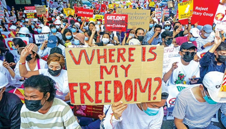 Protesters hold signs as they take part in a demonstration against the military coup in front of the Indonesian embassy in Yangon on Wednesday. — AFP photo