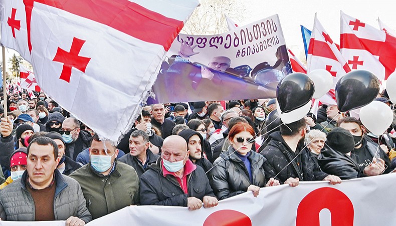 Georgian opposition parties members and supporters march demanding snap polls — three days after police arrested a top opposition leader and raided his party headquarters — in downtown Tbilisi on Friday. — AFP photo