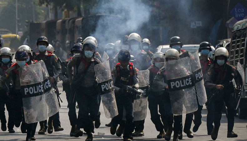 The police run holding shields as they attempt to disperse protesters taking part in a demonstration against the military coup in Yangon on February 27, 2021. — AFP photo