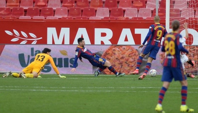 Barcelona forward Lionel Messi scores his team’s second goal against Sevilla during their La Liga match at the Ramon Sanchez Pizjuan stadium in Seville on Saturday. — AFP photo