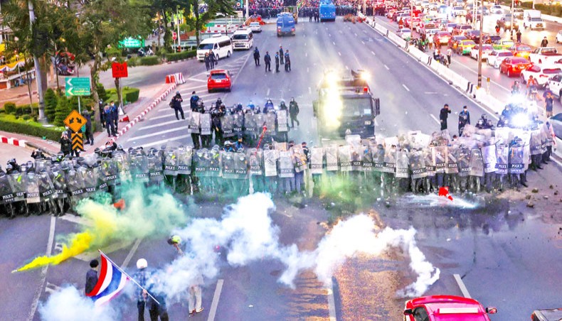 Tear gas canisters are seen on the road as riot police face off with pro-democracy protesters taking part in a demonstration headed toward the residence of Thailand’s prime minister Prayut Chan-O-Cha in Bangkok on Sunday. — AFP photo