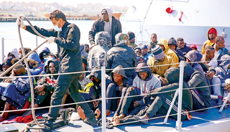 Rescued migrants sit aboard a Libyan coastguard vessel upon its arrival at the capital Tripoli’s naval base on Sunday. — AFP photo