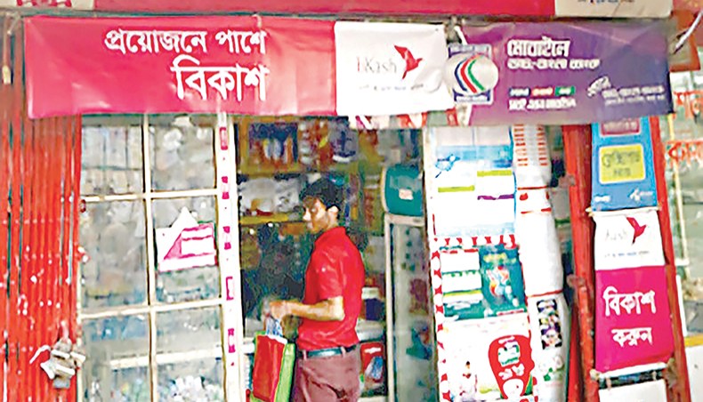 A file photo shows a man standing inside a shop that gives mobile financial service and mobile recharge service in Dhaka. The number of mobile financial service accounts surpassed 10 crore at the end of January with the monthly transaction through the MFS reaching Tk 57,253.11 crore. — New Age photo