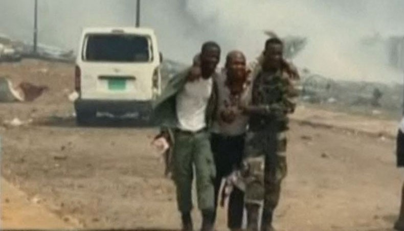 This video grab obtained by AFPTV from TVGE on March 7, 2021 shows an injured man being assisted by soldiers in Bata, Equatorial Guinea. -- AFP photo