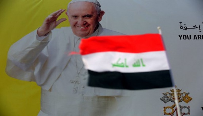 The Iraqi flag, with the Arabic writing Allah w Akbar (God is the Greatest) in the centre, flutters in front of a canvas displaying Pope Francis in Baghdad on March 5, 2021, hours before the start of the pontiff' first visit to Iraq.- AFP photo