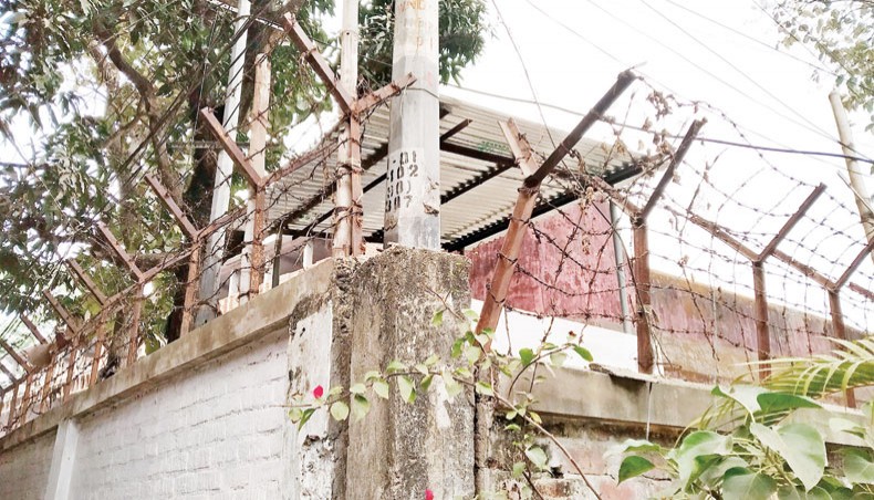 Torn barbed-wire fence of the Chattogram Central Jail wall allegedly facilitated an inmate to escape recently. The photo was snapped on Wednesday. — New Age photo