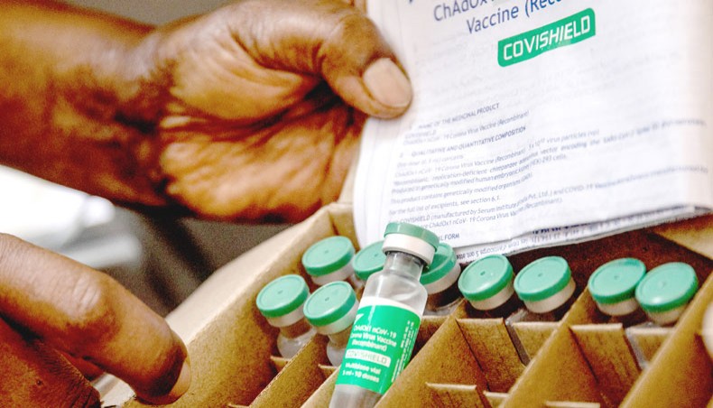 A staff member of Uganda’s ministry of health holds a box of Oxford/ AstraZeneca COVID-19 vaccines at Mulago referral hospital in Kampala on the first day of a vaccination campaign on March 10. — Agence France-Presse/Badru Katumba