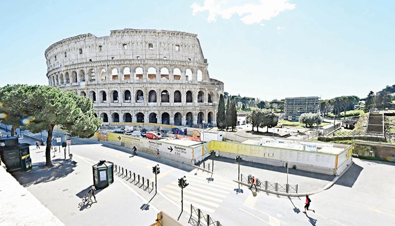 Streets are almost empty in front of the Ancient Colosseum in central Rome, on Monday, as three-quarters of Italians entered a strict lockdown with the government implementing restrictive measures to fight the rise of COVID-19 infections. — AFP photo