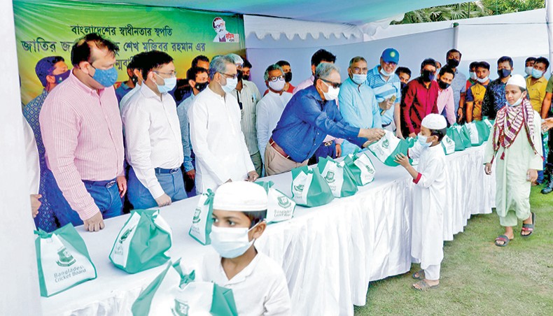Bangladesh Cricket Board president Nazmul Hasan distributes food among the poor on the occasion of birth centenary of country’s founding president Sheikh Mujibur Rahman in Mirpur on Wednesday. — BCB photo