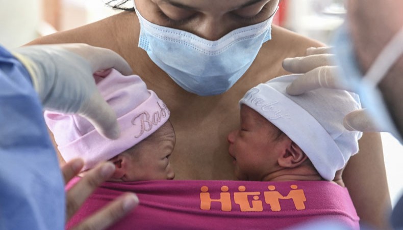 In this file photo taken on May 21, 2020 a mother breast feeds her newly born twins as a doctor helps her, during the novel coronavirus COVID-19 pandemic, at the post-natal lactation room at the Medellin General Hospital, in Medellin, Colombia. -- AFP photo