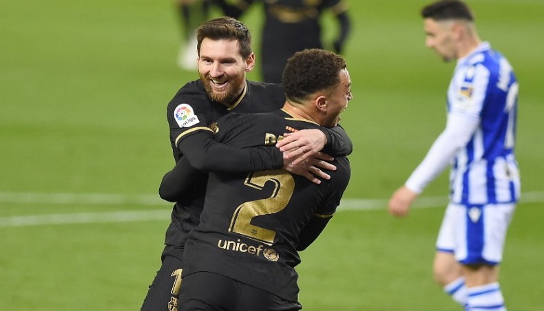 Barcelona defender Sergino Dest celebrates with Lionel Messi (back) after scoring a goal during their La Liga match against Real Sociedad at the Anoeta stadium in San Sebastian on Sunday. — AFP photo