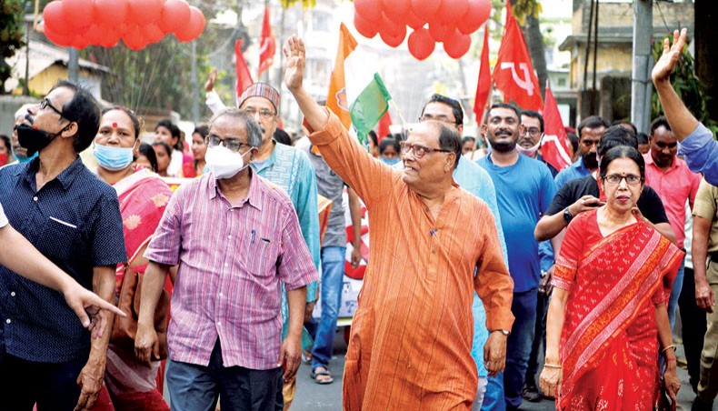 Communist Party of India (Marxist) candidate supported by Indian National Congress for the Siliguri Assembly constituency waves during a door to door campaign in Siliguri on March 20. — Agence France-Presse/Diptendu Dutta