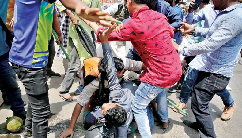 Some activists try to protect a police officer as some people beat him during a clash between the activists of Bangladesh Chhatra O Juba Odhikar Parishad and the police at Motijheel in Dhaka on Thursday. — Sourav Lasker