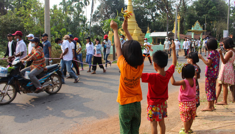 This hand-out photo taken and released by Dawei Watch on March 27, 2021 shows children gesturing to protesters during a demonstration against the military coup in Dawei. — AFP photo