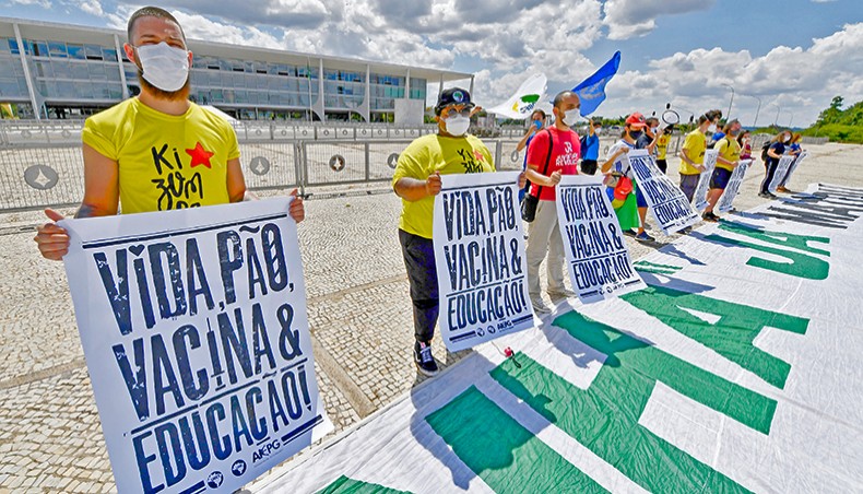 Demonstrators hold signs during a protest against Brazilian president Jair Bolsonaro’s government outside the Planalto Palace in Brasilia, under the slogan ‘Life, Food, Vaccine and Education’, on Tuesday. — AFP photo