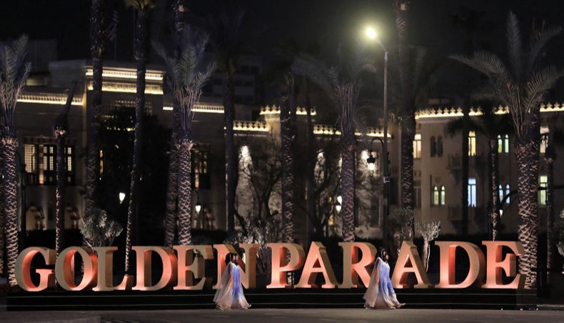 Performers dressed in ancient Egyptian costume walk past the Golden Parade sculpture in the capital Cairo's Tahrir Square at the start of the parade of 22 ancient Egyptian royal mummies departing from the Egyptian museum on April 3, 2021. — AFP photo