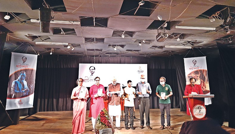 Guests pose holding copies of Mohammad Bari’s play Tin Galper Natyayan at a programme held at the Studio Theatre Hall of Bangladesh Shilpakala Academy on Saturday. — Press release