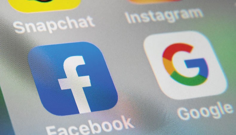 A file photo shows the logos of mobile apps Facebook and Google displayed on a tablet in Lille, France. A bipartisan group of US senators has sent letters to major digital ad exchanges, including Google and Twitter, asking whether user data was sold to foreign entities who could use it for blackmail or other malicious ends. — AFP photo