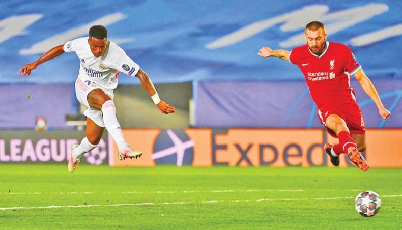Real Madrid forward Vinicius Junior (L) shoots to score his team’s opening goal against Liverpool during their UEFA Champions League quarter-final first-leg match at the Alfredo di Stefano stadium in Madrid on Tuesday. — AFP photo