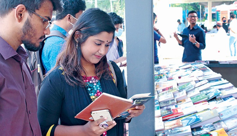 Young people visit a bookstall at Amar Ekushey Book Fair in Dhaka without wearing masks on Wednesday. — New Age photo