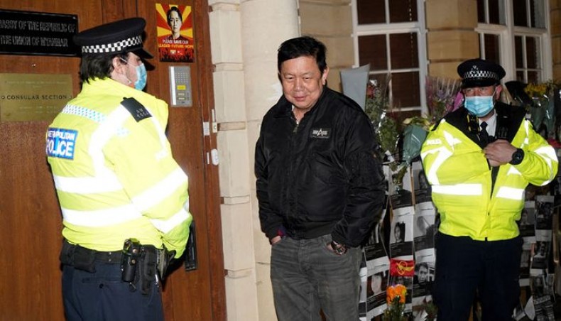 Myanmar's ambassador to the United Kingdom, Kyaw Zwar Minn, stands with police officers locked outside the Myanmar embassy in London on April 7, 2021. -- AFP photo