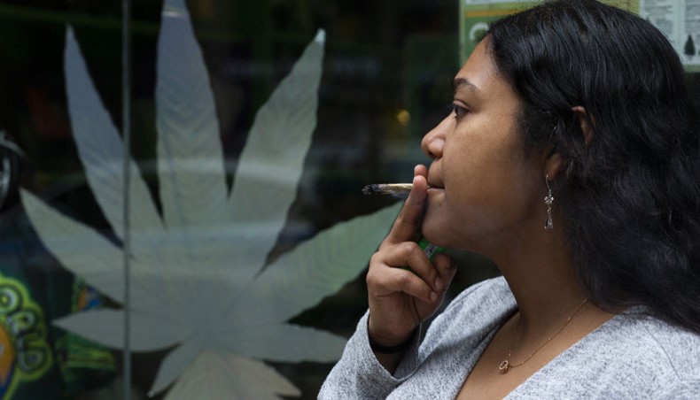 Eliana ‘Miss Illi,’ general manager of weed World poses as she smokes a joint on 7th avenue in Midtown New York City, March 31, 2021. -- AFP photo