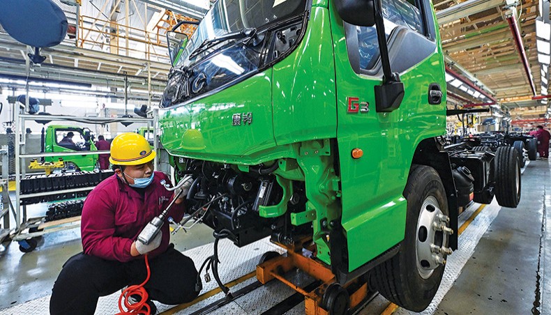 A file photo shows an employee working on a truck assembly line at a factory for vehicle manufacturing company Jianghuai Automobile Group Corp in Qingzhou in eastern China’s Shandong province. — AFP photo