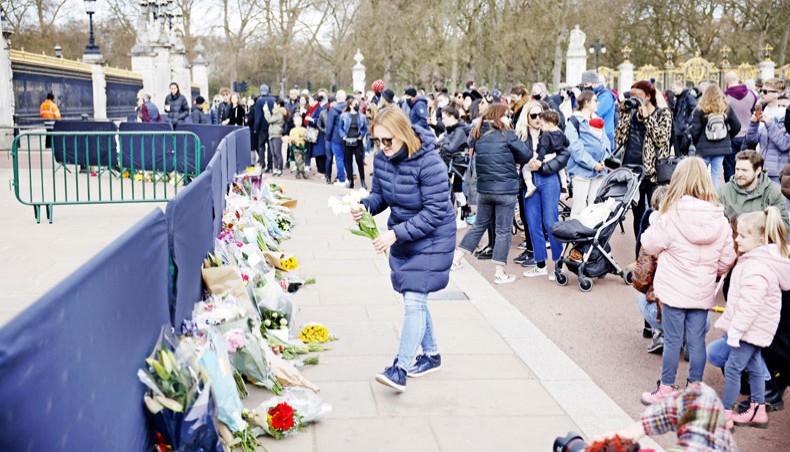 Well-wishers add flowers to the tributes outside Buckingham Palace in central London, on Sunday, two days after the death of Britain’s Prince Philip, Duke of Edinburgh, at the age of 99. — AFP photo