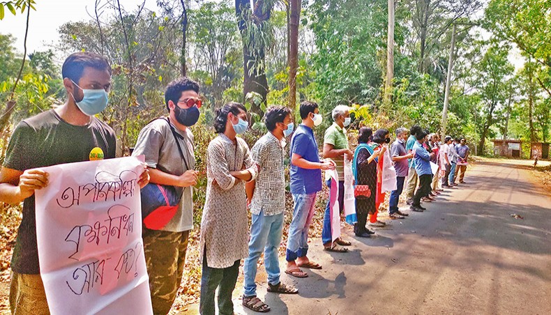 Jahangirnagar University teachers and students form a human chain in front of the university’s botanical garden on Sunday in protest at random tree felling on the campus. — New Age photo