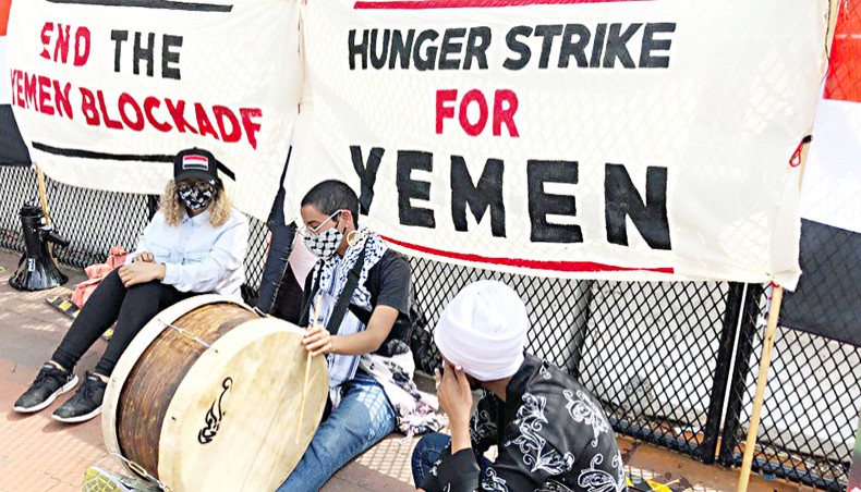 Iman Saleh (with drum) on hunger strike in Washington, DC to protest the blockade and war against Yemen; seated next to her is US representative Ilhan Omar. — Common Dreams/Hassan El-Tayyab