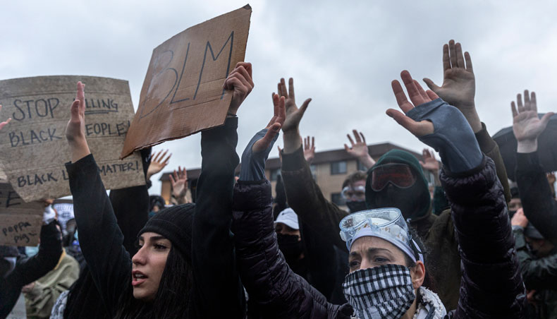 Demonstrators raise their hands at the start of curfew in protest over the death of Daunte Wright who was shot and killed by a police officer in Brooklyn Centre, Minnesota on April 12, 2021. — AFP photo
