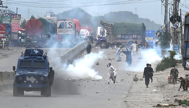 Supporters of Tehreek-e-Labbaik Pakistan party throw stones over the police armoured vehicle during a protest against the arrest of their leader as he was demanding the expulsion of the French ambassador over depictions of Prophet Muhammad, in Barakahu neighbourhood of Islamabad on April 13, 2021. — AFP photo