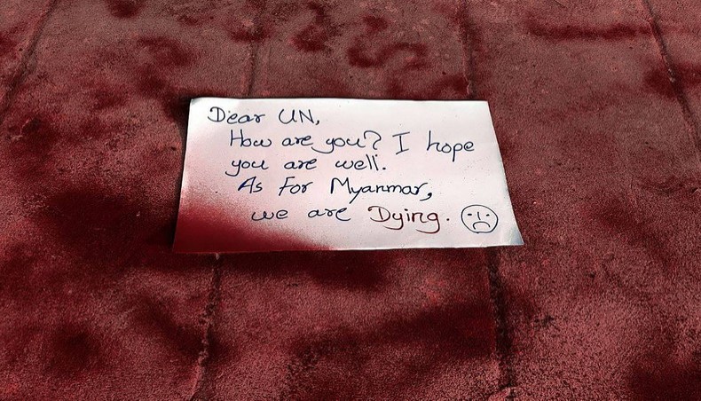 This photo taken and received courtesy of an anonymous source via Facebook on April 14, 2021 shows a protest sign appealing to the United Nations on red spray paint on the ground as part of a ‘bleeding strike’ demonstration against the military coup in East Dagon township in Yangon. -- AFP