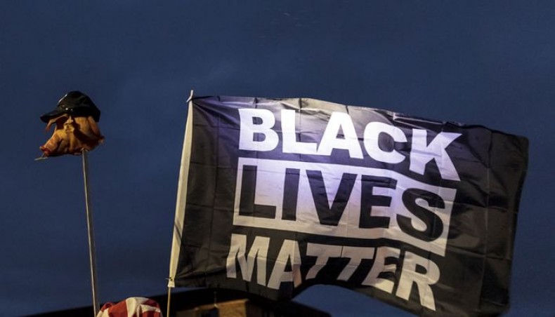 Demonstrators brandish a pig's head on a pike and fly a Black Lives Matter flag outside the Brooklyn Centre police station while protesting the death of Daunte Wright who was shot and killed by a police officer in Brooklyn Center, Minnesota on April 14, 2021. -- AFP photo