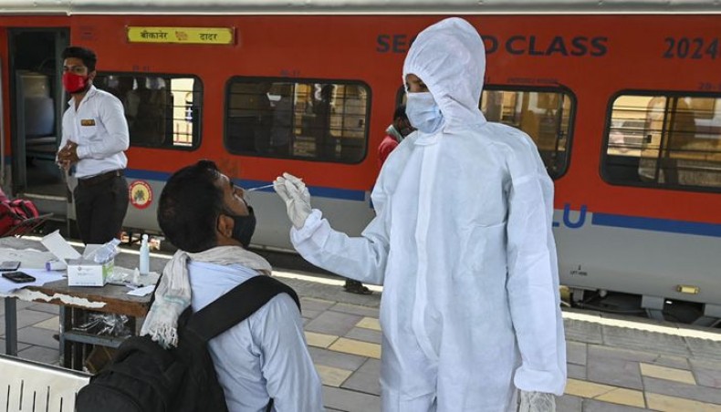 A health worker takes a nasal swab sample of a passenger for the Covid-19 coronavirus test after arriving at a railway platform on a long distance train, in Mumbai on April 14, 2021. -- AFP Photo