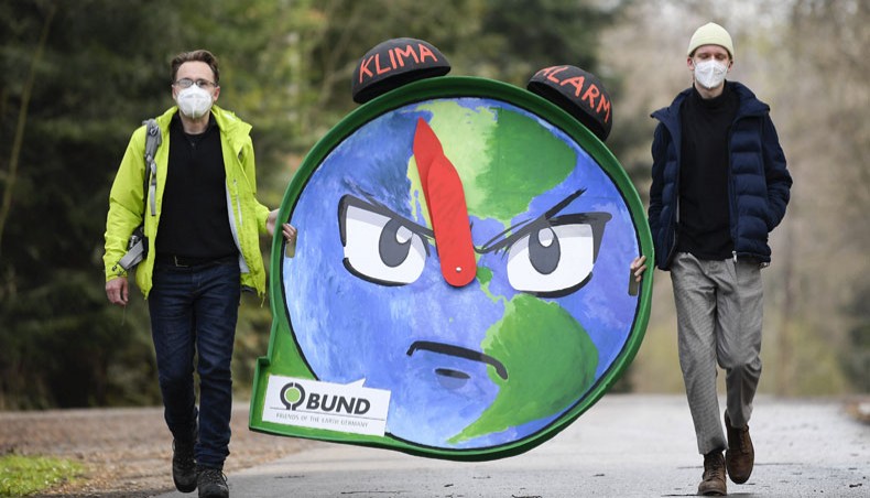 Climate activists carry a climate alarm clock to the location of the coalition talks of Baden-Wuerttemberg’s Green party and the CDU in Stuttgart, southern Germany, on April 8, 2021. — AFP photo