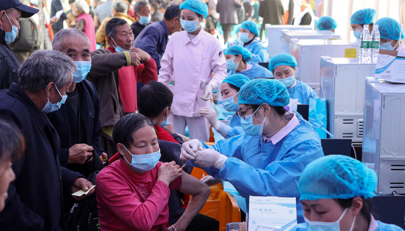 This photo taken on April 12, 2021 shows people receiving the China National Biotec Group COVID-19 coronavirus vaccine in China’s south-western Chongqing. — AFP photo