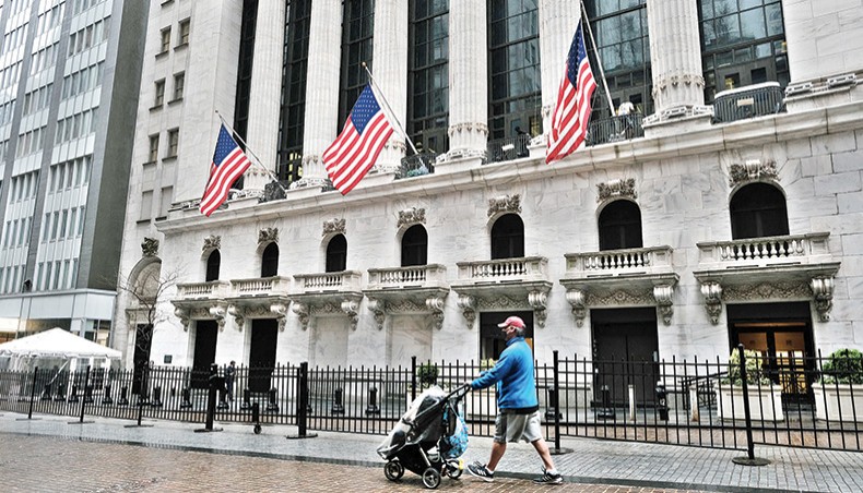 People walk by the New York Stock Exchange on April 15, 2021 in New York City. Global stock markets rose on Friday as strong economic data out of China fuelled optimism over the global economic recovery. — AFP photo