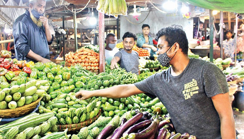 A vendor sells vegetables, including aubergine, at his shop at Kaptan Bazar kitchen market in the capital on Friday. — Focusbangla photo