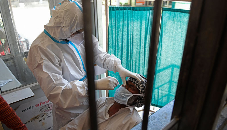 A health worker collects a nasal swab sample from a man to test for COVID-19 in Amritsar on April 18, 2021. — AFP photo