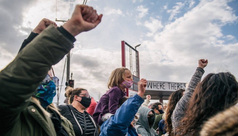 A child sits on an adult’s shoulders during a celebration of the guilty verdict in the trial of Derek Chauvin at the intersection of 38th Street and Chicago Avenue on April 20. — AFP photo