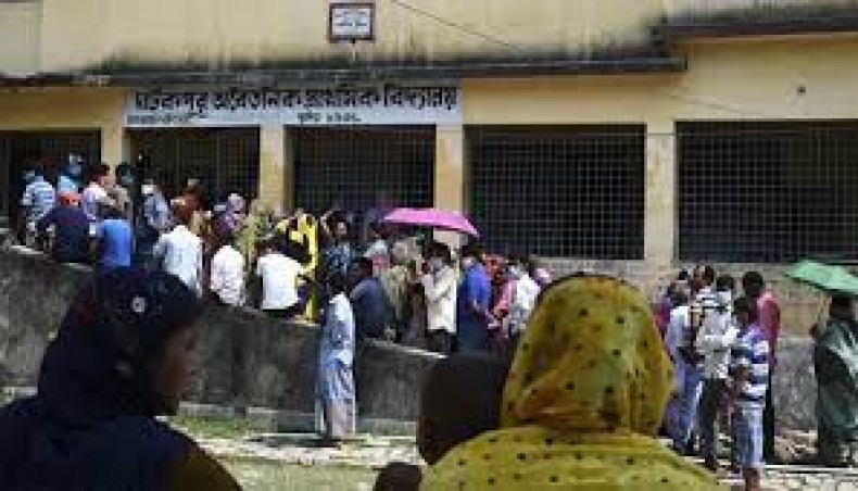 People stand into a queue to cast their votes at a polling station during the third phase of the state legislative elections, at South Twenty Four Parganas district, about 70 km from Kolkata on April 6. — AFP Photo