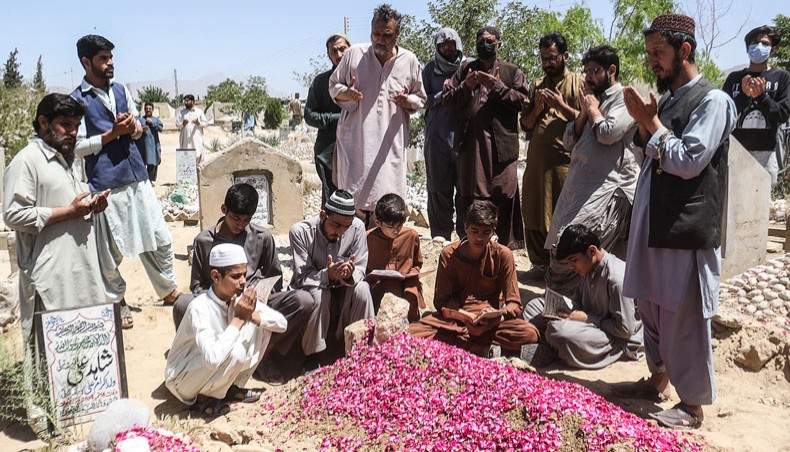 Relatives pray on the grave of a victim killed in a deadly suicide blast at a luxury hotel hosting the Chinese ambassador in the southwest of the country, in Quetta on April 22, 2021. — AFP Photo