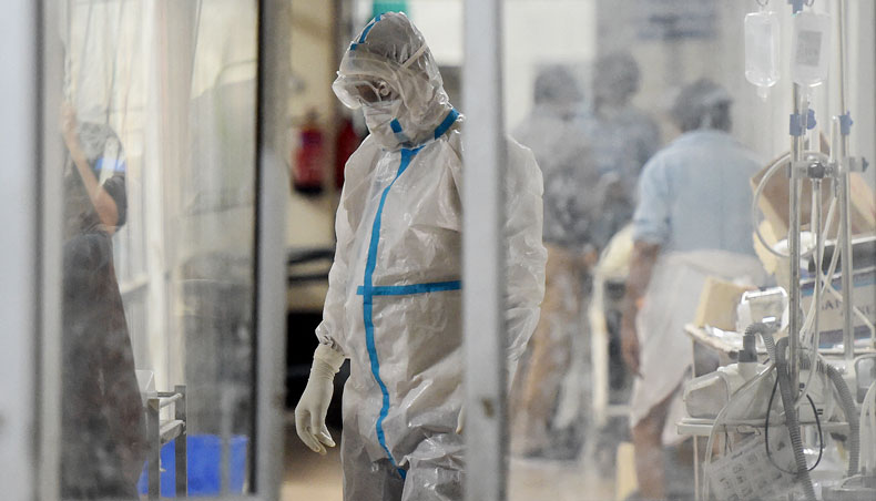 A health worker wearing a personal protective equipment suits attends a Covid-19 patient inside a Covid-19 ward at the SRN hospital, in Allahabad on May 3, 2021. — AFP photo