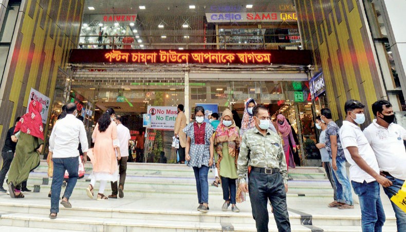 Buyers come out of Paltan China Town market in Dhaka after it was briefly shut down on Tuesday for the widespread violation of the Covid health guidelines. — New Age photo