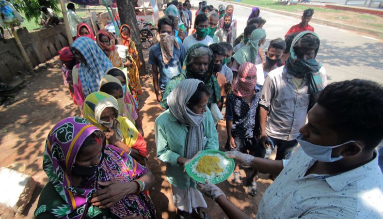 Social workers distribute cooked food to people during a nationwide lockdown against the Covid-19 coronavirus in the eastern Indian state Odisha's capital city Bhubaneswar, May 5, 2020. — AFP