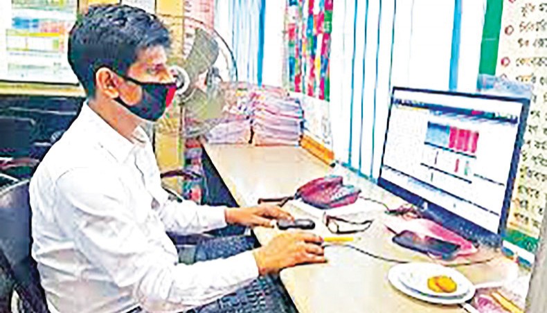 A file photo shows a person monitoring share price movements on a monitor at a brokerage house in the capital. Dhaka stocks increased for the third day on Thursday with the key index hitting a three-month high as investors continued buying shares amid the relaxation of Covid restrictions by the government. — New Age photo